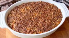 a white casserole dish filled with food on top of a wooden table