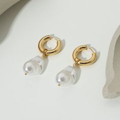 Indulge in the timeless elegance of Pearl Huggie Earrings, exquisitely crafted in 18k gold plating. These snug-fitting earrings blend the lustrous beauty of pearls with a contemporary huggie design. Elegant Gold Pearl Huggie Earrings, Elegant Gold Huggie Earrings With Pearl Charm, Minimalist Gold Plated Pearl Drop Earrings, Minimalist Gold-plated Pearl Drop Earrings, Elegant Gold Plated Huggie Earrings With Pearl Drop, Elegant Gold-plated Huggie Earrings With Pearl Drop, Classic Pearl Pendant Earrings In 14k Gold Filled, Elegant Pearl Huggie Dangle Earrings, Elegant Everyday Huggie Earrings With Pearl Charm