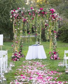 an outdoor wedding setup with white chairs and pink flowers