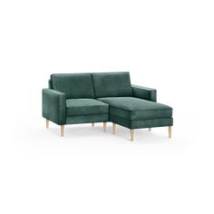 a green couch with a footstool sitting on it's backrests