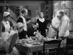 a group of people standing around a dining room table with food on top of it