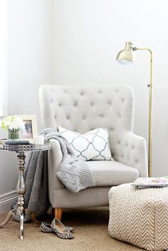 a living room with a chair and ottoman