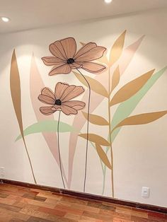 an empty room with flowers painted on the wall and wood flooring in front of it