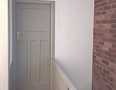 an empty hallway with a door and brick wall