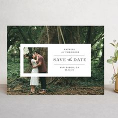 the save the date photo card is displayed next to a potted plant and vase