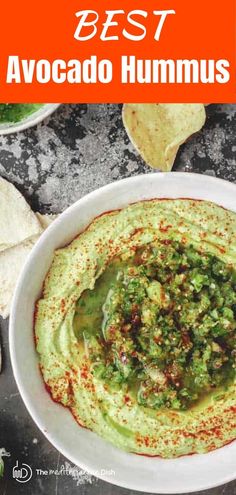 the best avocado hummus is in a bowl with tortilla chips