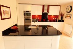 a black and white kitchen with red accents