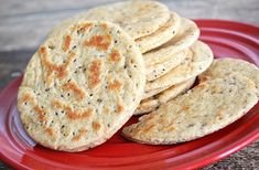 a red plate topped with crackers on top of a wooden table