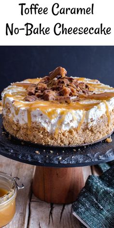 a cheesecake with caramel sauce and whipped cream on top is sitting on a cake stand