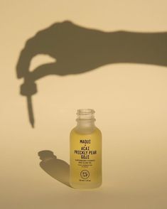 a person's hand holding a small bottle with a knife sticking out of it