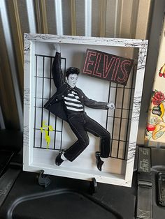 elvis presley in jail cell with neon sign on it's head and hands behind bars