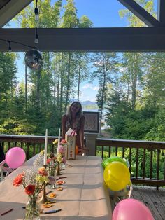 a woman sitting at a long table with balloons