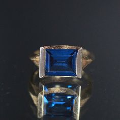 Absolutely Beautiful! Featuring This 14k Gold Ring Mounted With 3.29 Cts Squared Blue Synthetic Spinel Bezeled Set In A Textured Modernist Setting. This Is Size 6 And Weighs 3.38 Grams. Stock Code: 2p2205-3-24 Blue 14k Gold Ring With Prong Setting, Blue 14k Gold Ring Stamped 14k, Timeless Blue Sapphire Ring With Diamond Cut, Modern Blue Sapphire Ring For Formal Occasions, 14k Gold Blue Ring With Prong Setting, Blue 14k Stamped Promise Ring, Formal Blue Sapphire Ring, Timeless Blue Diamond Cut Ring, Blue Sapphire Ring Stamped 14k For Gift