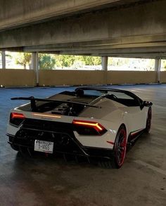 a white and black sports car parked in a parking garage