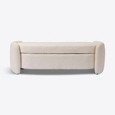 an upholstered white bench with arms and legs, made out of wool fabric