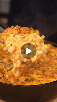 a skillet filled with macaroni and cheese being lifted by a ladle