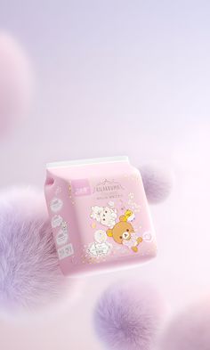 a pink package with pom poms around it on top of a purple background