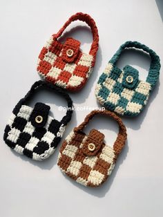 four crocheted purses sitting on top of a white table next to each other