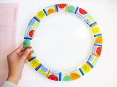 a person is holding a plastic toy in front of a circular object on the wall