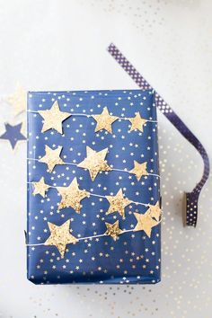 a blue gift box with gold stars on it