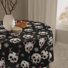 a table covered with skulls and candy canes next to a vase filled with apples