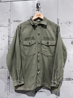 70's OG-107 Fatigue Button Up Shirt- Vietnam War(Army Green)  Fair vintage condition. See pictures for condition 15.5x33 . Please review measurements as some vintage items fit smaller than modern sizing. Measurements taken with garment laid flat: 21" across from armpit to armpit 27" length from shoulder to hem 23" sleeve from shoulder to hem Please send a message if you have any questions. Double check measurements and inspect all pictures carefully before purchasing. Orders ship via USPS. All s Retro Khaki Button-up Shirt, Retro Khaki Cotton Shirt, Vintage Green Button-up Shirt, Vintage Cotton Shirt With Spread Collar, Vintage Long Sleeve Tops With Pockets, Vintage Pre-washed Cotton Tops, Retro Button-up Shirt With Pockets, Retro Long Sleeve Khaki Shirt, Vintage Khaki Shirt With Pockets