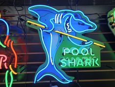 several neon signs on the side of a building that says pool shark with a dolphin holding a baseball bat