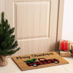 a door mat that says merry christmas with a red pickup truck and pine tree on it