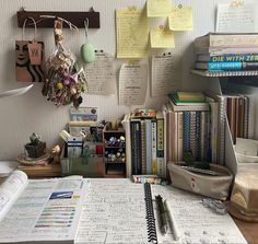 a cluttered desk with many books and papers on the top, including notebooks