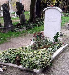 a grave surrounded by plants in a cemetery