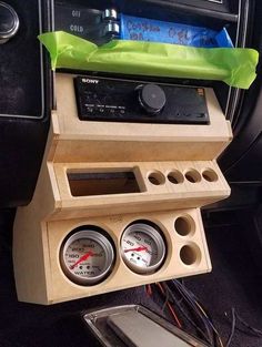 a car dashboard with two gauges and an air freshener box in the center