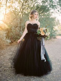 a woman in a black dress holding a bouquet