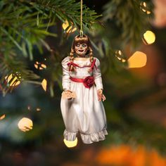 a doll ornament hanging from a christmas tree