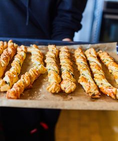 some food is being prepared on a tray and someone in the background has their hands behind them