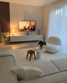 a living room filled with furniture and a flat screen tv on top of a wall