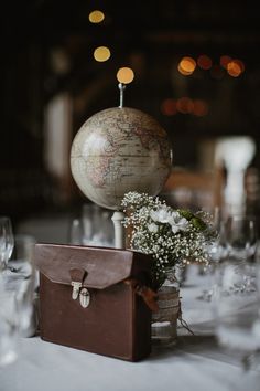 a table topped with a suitcase and a globe