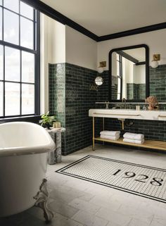 a bath room with a tub a sink and a mirror on the wall next to a window