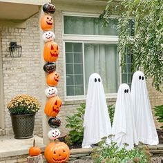 halloween decorations in front of a house with pumpkins