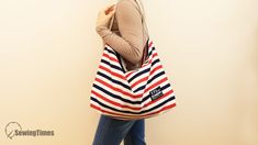 a woman carrying a red, white and blue striped tote bag with zippered closures