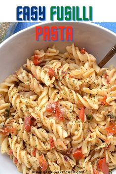 a pasta dish with tomatoes and herbs in a white bowl