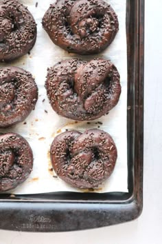 chocolate donuts with sprinkles sitting on a baking sheet, ready to go into the oven