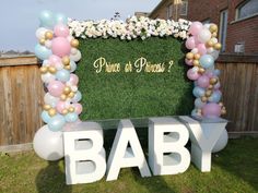 a baby shower sign with balloons and flowers