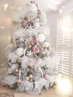 a white christmas tree decorated with ornaments