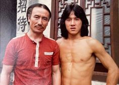 two men standing next to each other in front of a building with chinese writing on it