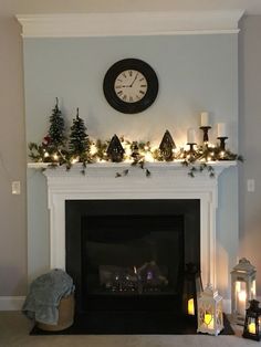 a fireplace decorated for christmas with lit candles