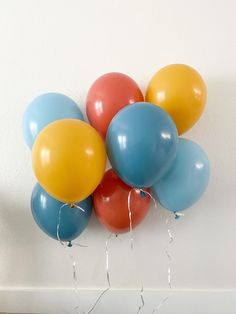 a bunch of balloons are hanging on the wall