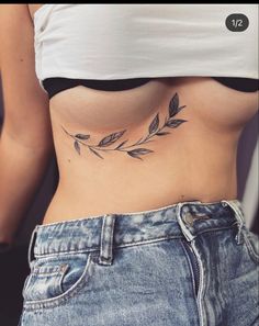 a woman's stomach with leaves tattoo on her belly and the bottom part of her stomach