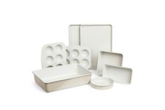 an assortment of white dishes and trays on a white background, with one empty plate in the middle