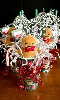 starbucks christmas baskets with teddy bears and candy canes in them on a wooden table