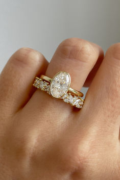 a woman's hand with a gold ring and two diamond rings on her fingers